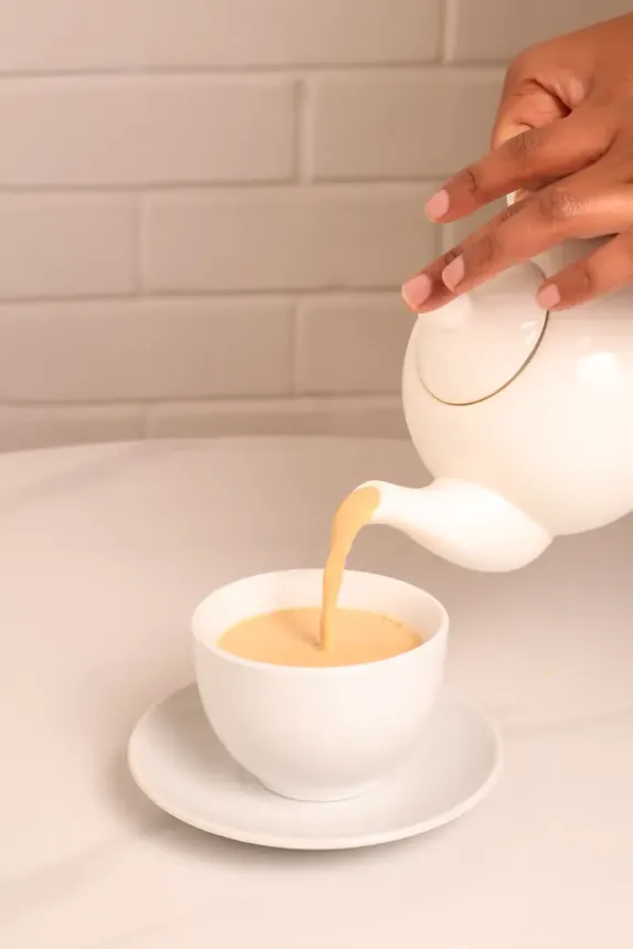 Camel tea being poured from a white teapot